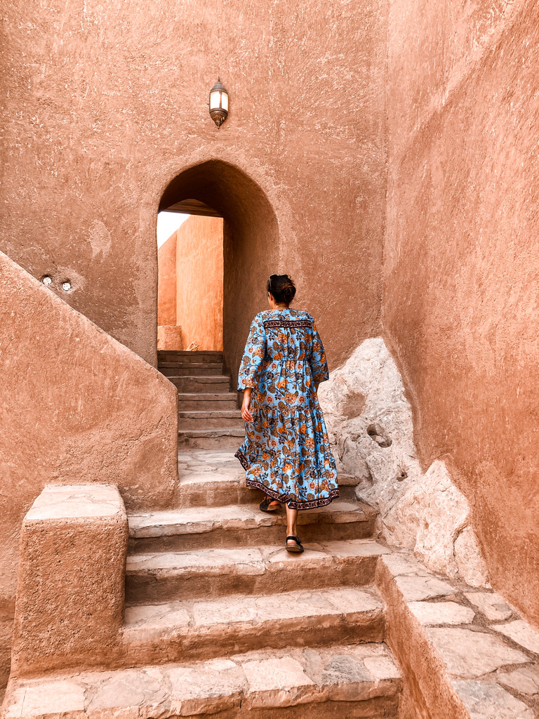 Solo female traveller exploring a historic fortress in Oman during off-the-beaten-path travel