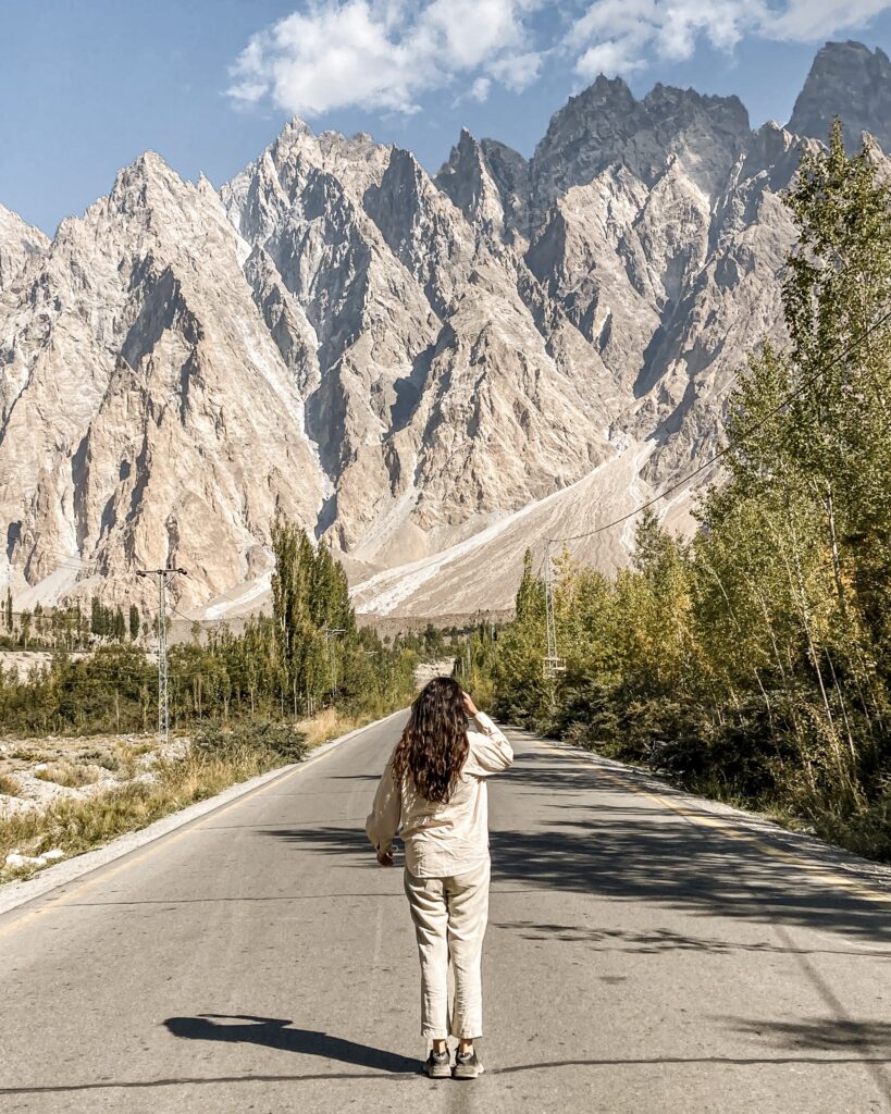 Woman traveller on the Karakoram Highway surrounded by rugged mountains in Pakistan
