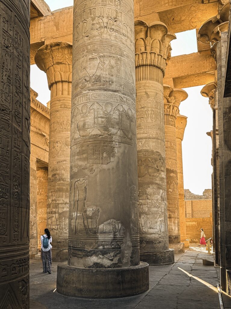 person walking through the columns in kom ombo