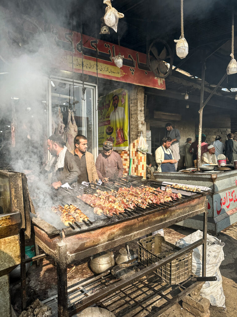 Men grilling lamb barbecue on the food streets of Namak Mandi, Peshawar, Pakistan