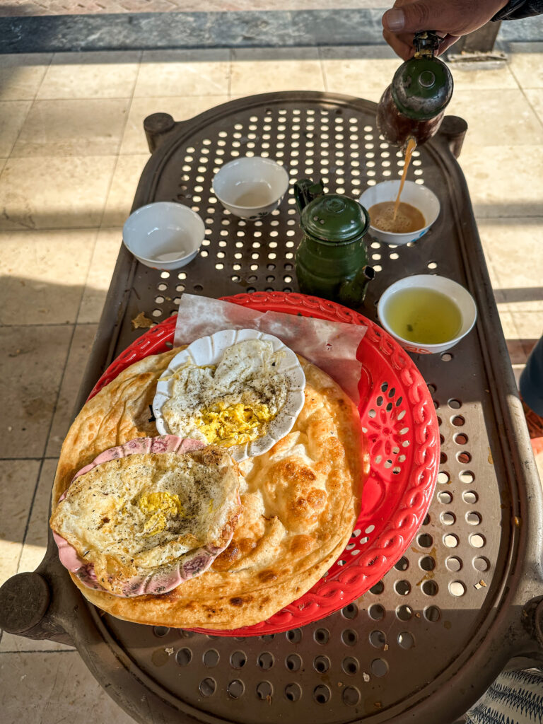 Traditional breakfast with paratha, eggs and local tea in Peshawar, Pakistan