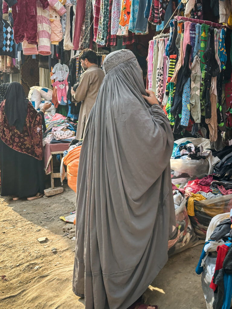 Local woman wearing a burqa in a street market, Peshawar, Pakistan